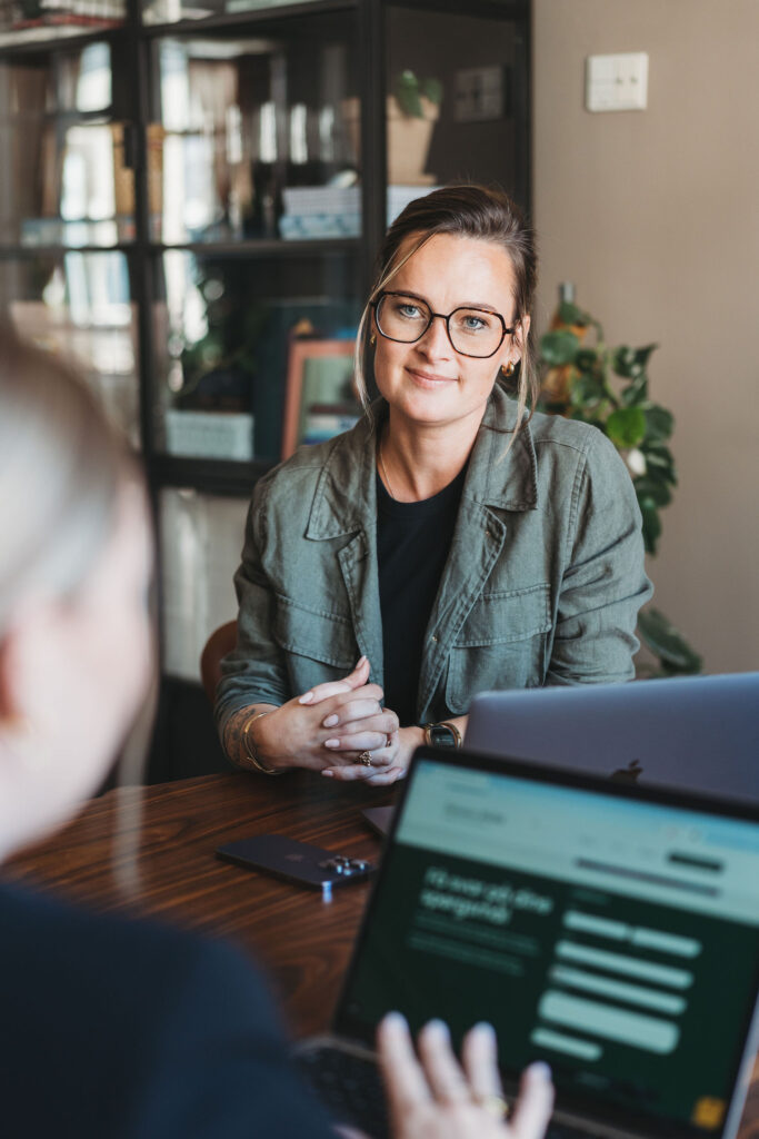 Rebekka Hviid i samtale, gennemgår SEO-rapport på bærbar computer.
