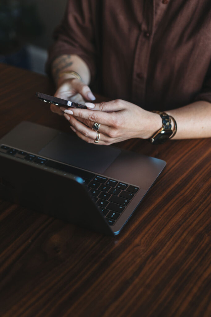 Person der bruger mobiltelefon og bærbar computer under 1:1 rådgivning.